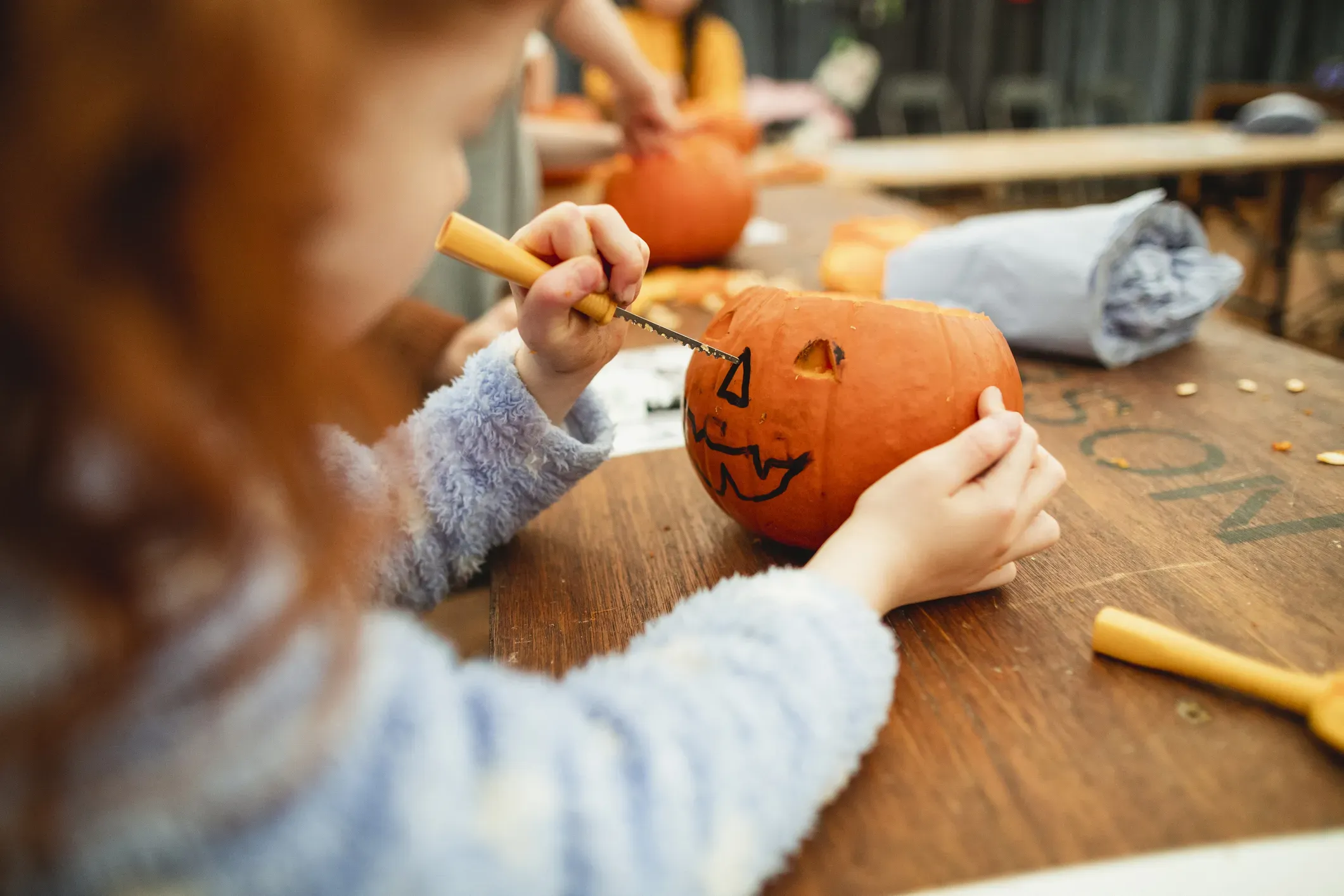 Ein Kind bastelt einen Gruselkürbis. Halloween bietet den idealen Rahmen für gruselige und gleichzeitig lustige Spiele mit Kindern. Mit zehn kreativen und einfach umzusetzenden Spielideen wird das Fest zu einem unvergesslichen Erlebnis. Die Spiele sind nicht nur spannend und schaurig, sondern auch leicht vorzubereiten.