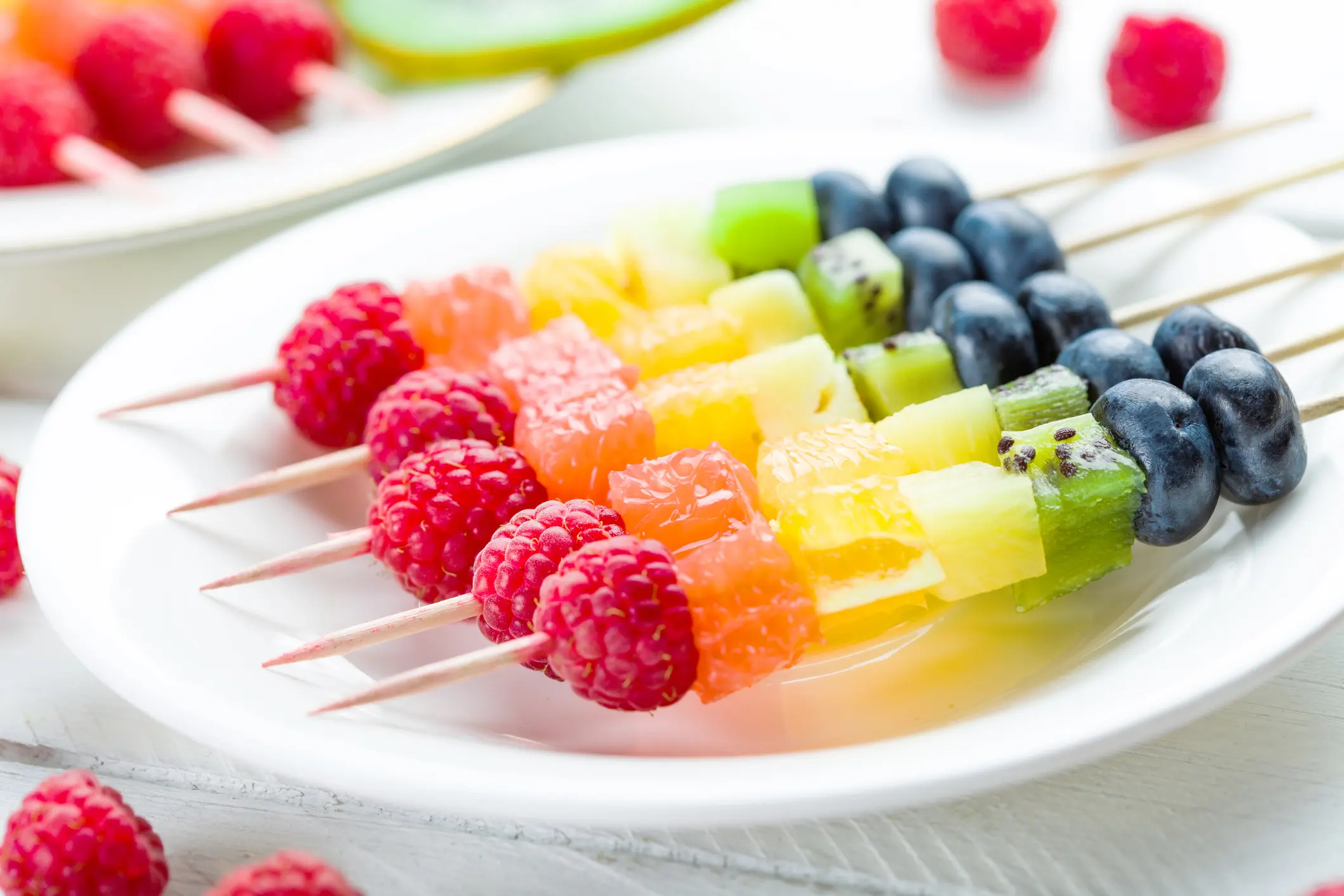 Farbenfrohe Obst- und Gemüsespieße, liebevoll arrangiert mit Sternen und Herzen ausgestochen, bieten eine gesunde und visuell ansprechende Snackoption für den Kindergeburtstag.