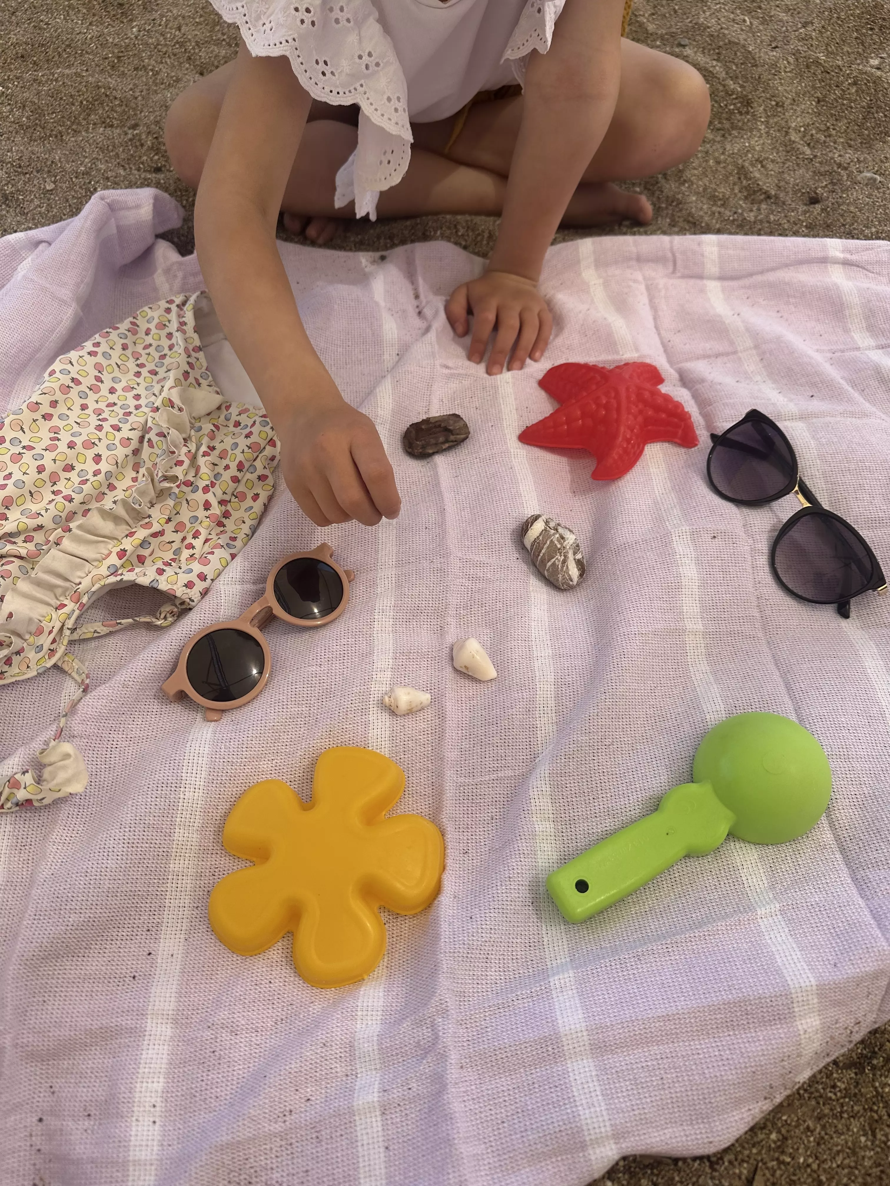 Ein einfaches und unterhaltsames Gedächtnisspiel am Strand, bei dem Kinder und Erwachsene ihre Beobachtungsgabe testen, indem sie erraten, welcher Gegenstand von einem Handtuch entfernt wurde.