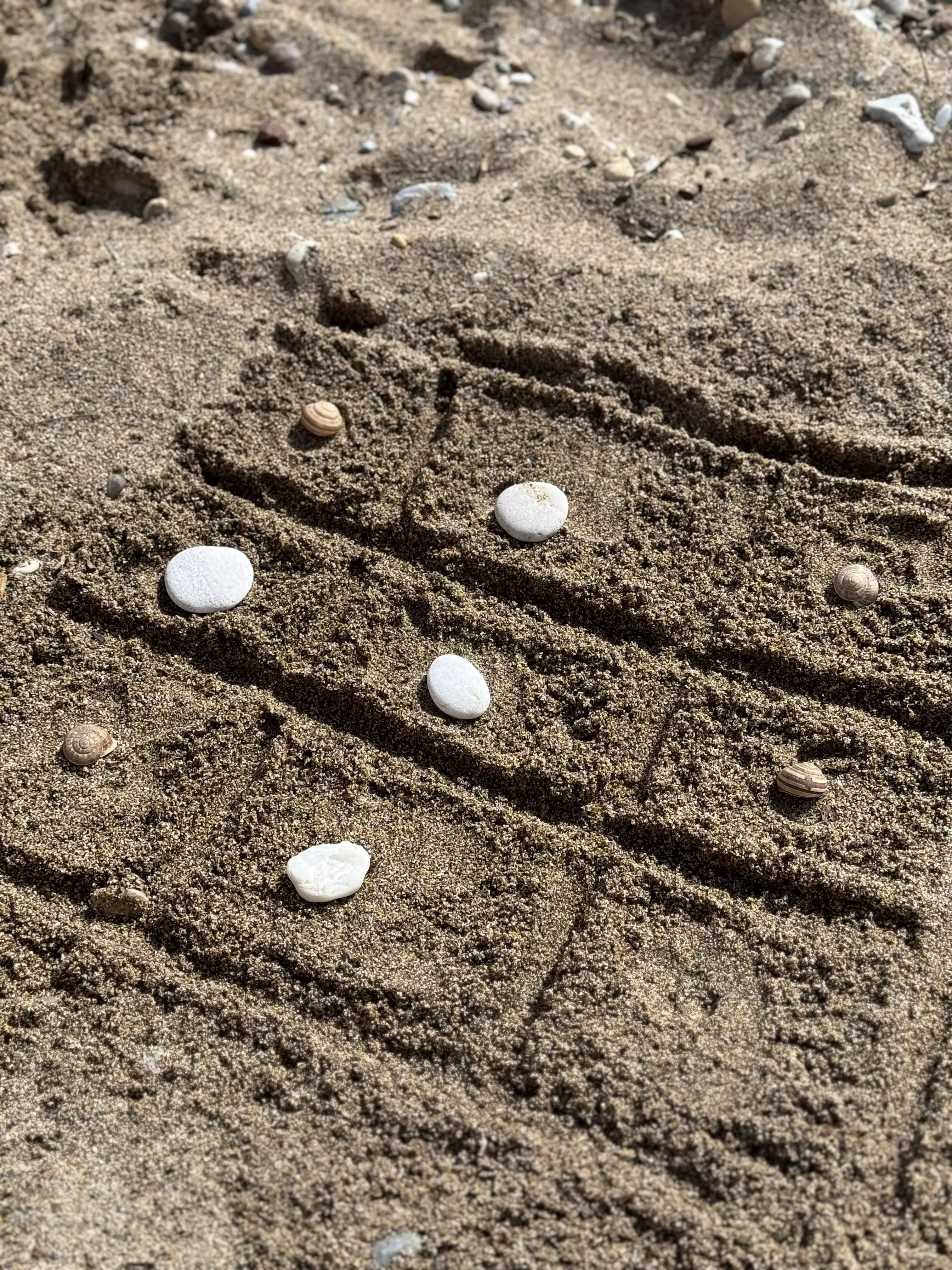 Das klassische Tic-Tac-Toe-Spiel, neu interpretiert im Sand, wo Spieler mit einem Stein oder Stöckchen das Spielfeld zeichnen und so direkt in der Natur spielen können.